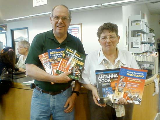 Jim, W4QO presents ham radio manuals to Leona Bolch of the Alpharetta Library.