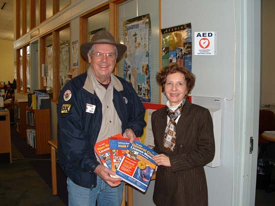 Jim, W4QO presents ham radio books contributed by NFARL to Lu Conti of the Roswell Library